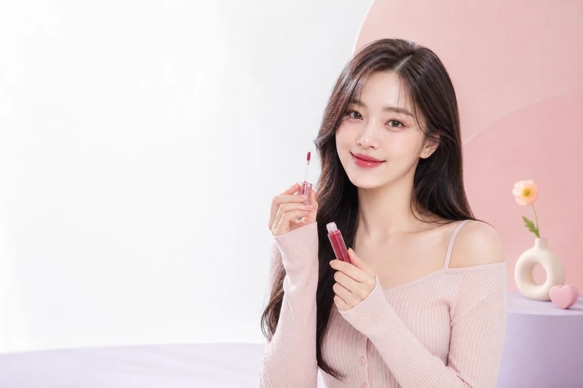 Korean beauty model applying a glossy lip tint in a pastel studio - Douyin Shop